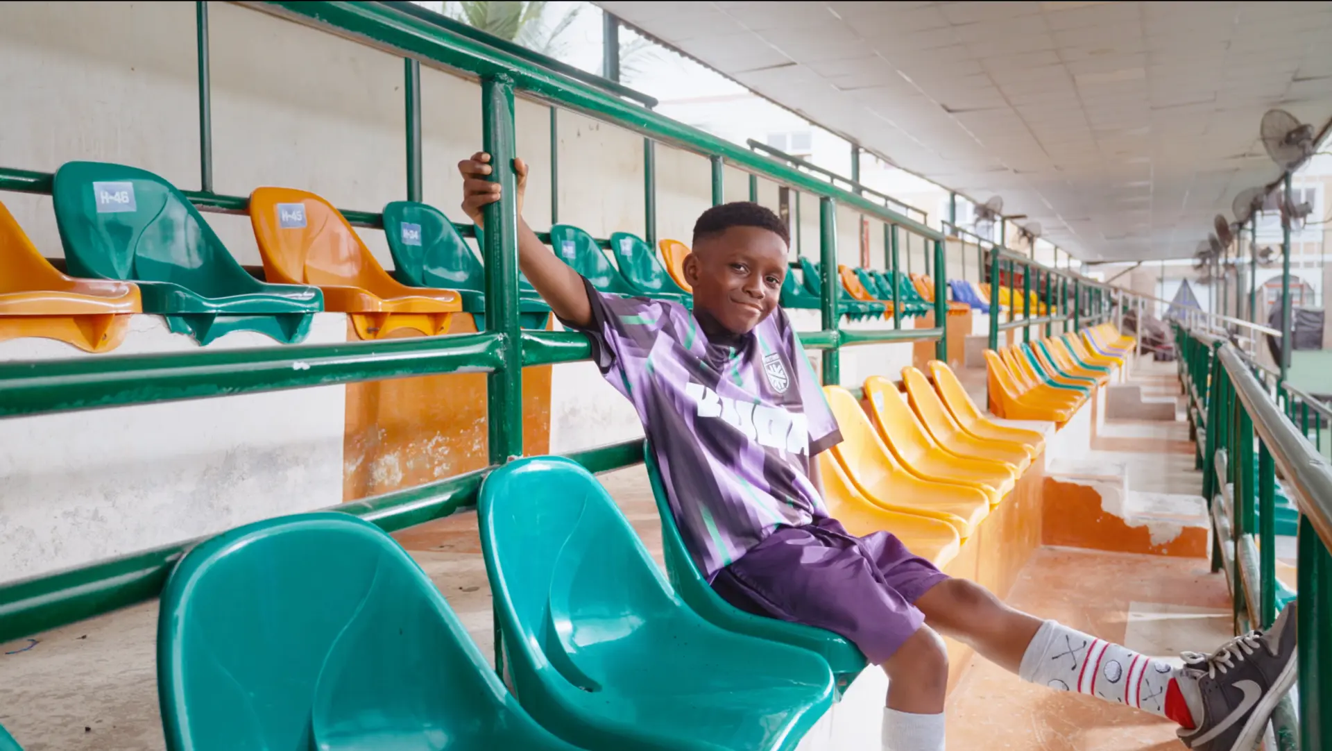 A group of models of all ages in Kuda football kits posing in front of a canvas backdrop